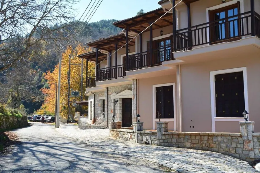 Ο ξενώνας από τον δρόμο, με βουνό και δέντρα στο βάθος
